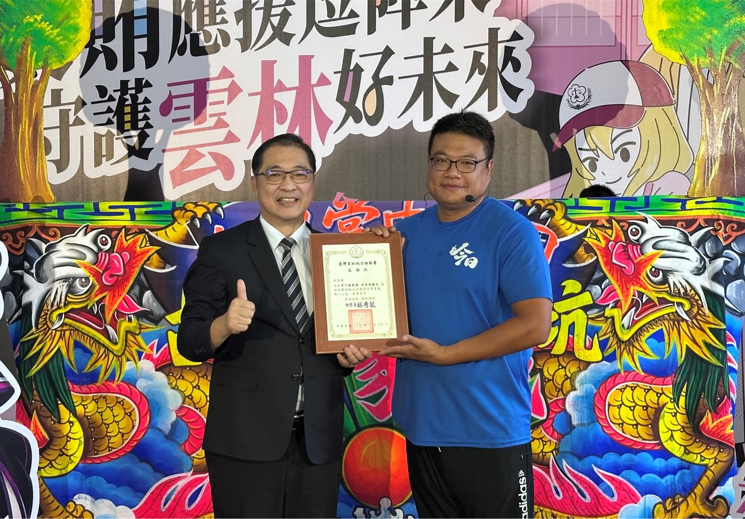 法務部部長鄭銘謙(左)致贈感謝狀給今日掌中劇團團長許家誠(右)